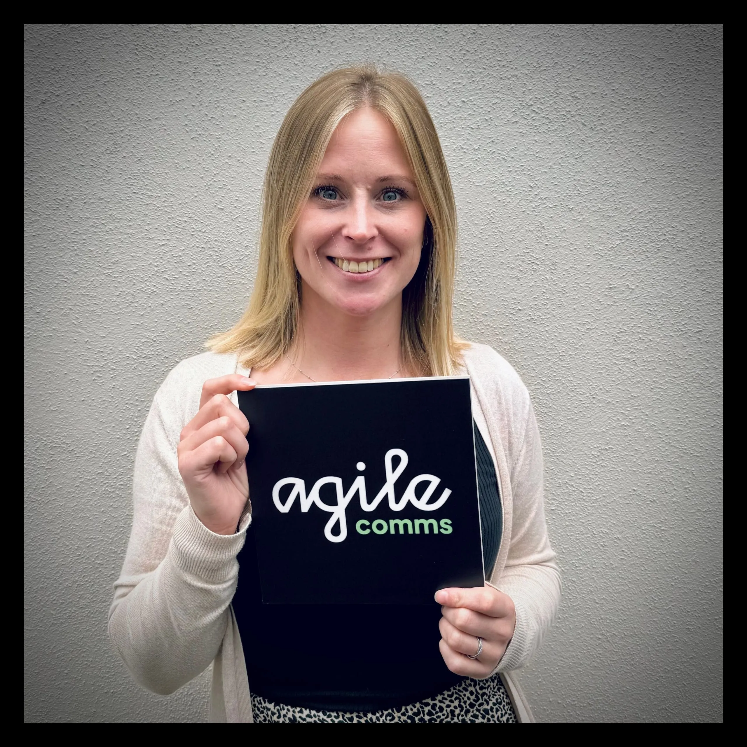 Aimee in front of the Agile Comms office sign
