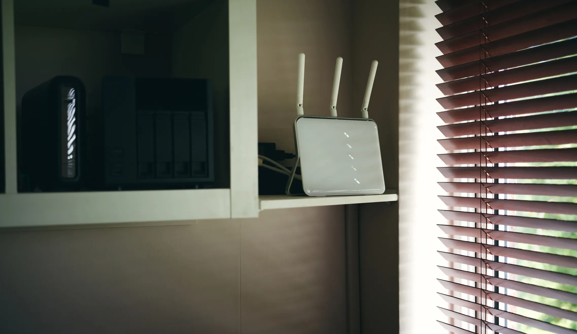 broadband router on a shelf next to a window in an office